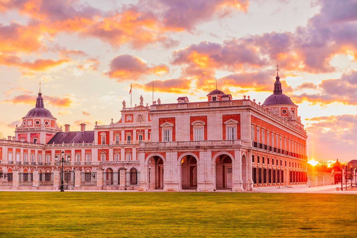 Exterior of a large royal palace at sunset.