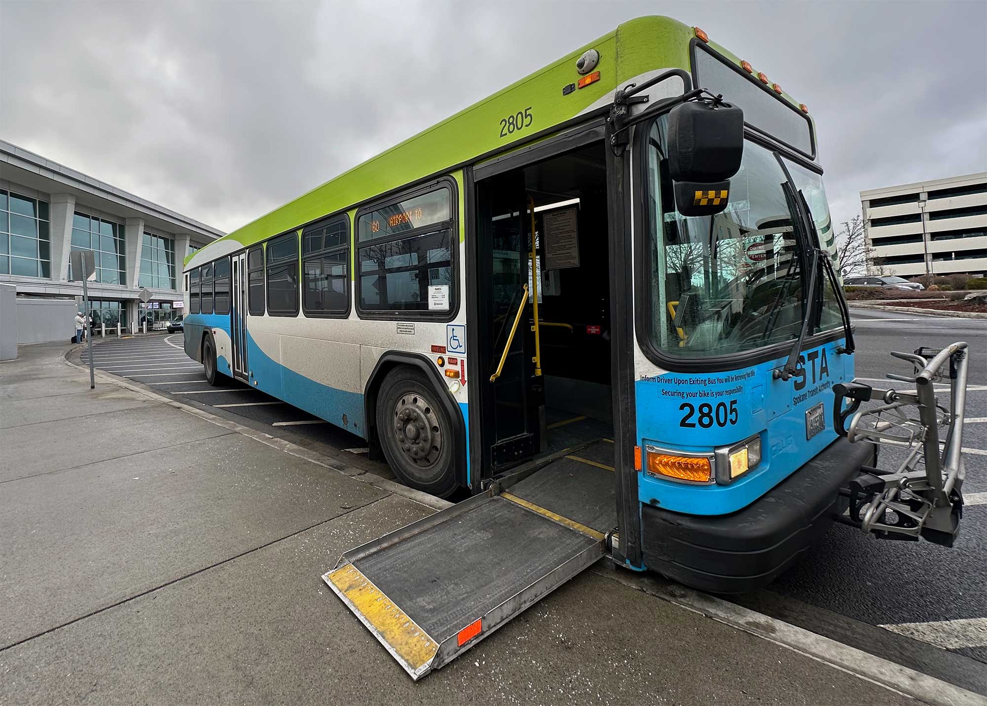 City bus with wheelchair ramp deployed onto curb.