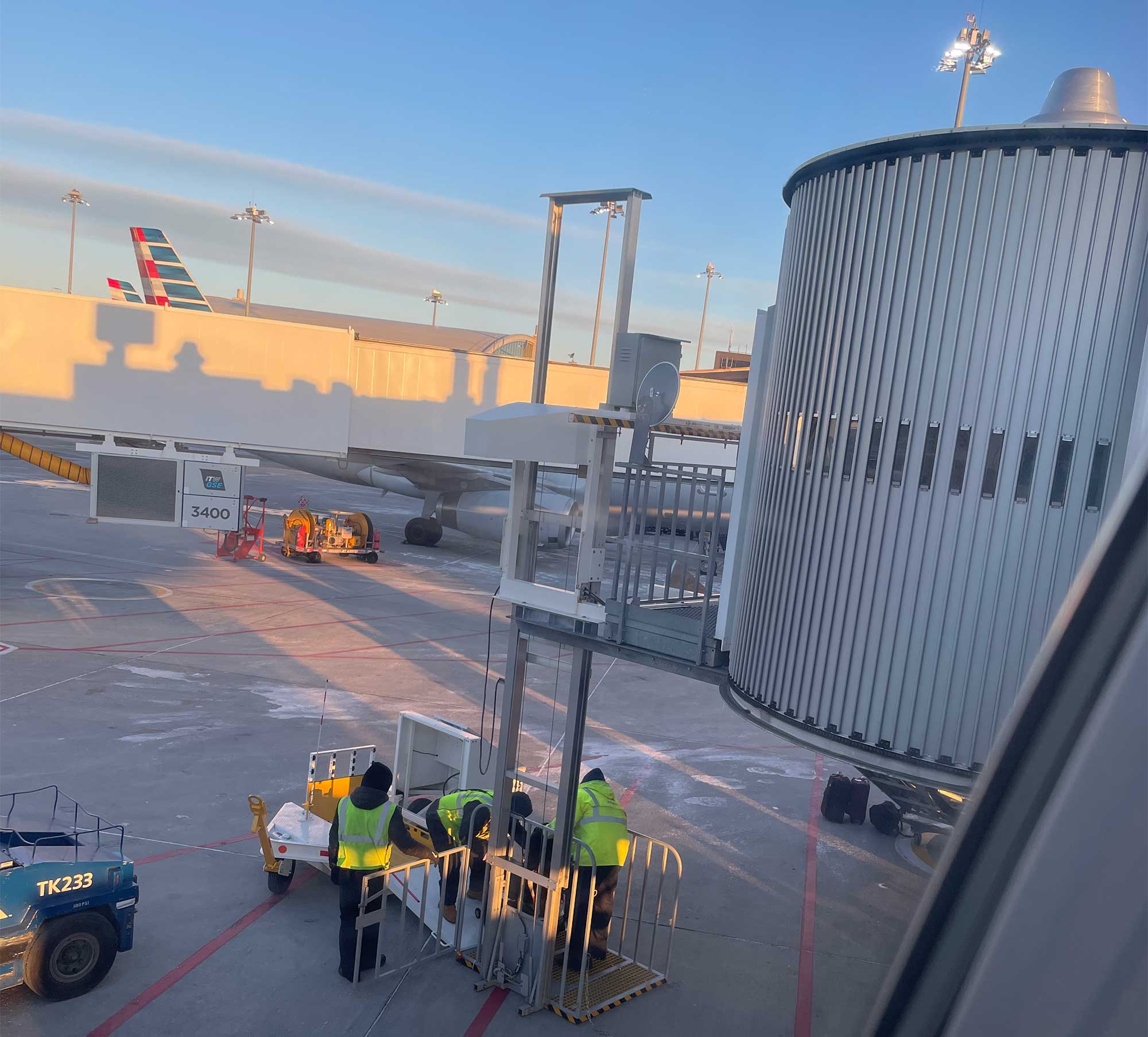 Wheelchair being loaded onto special lift attached to a jetway at Boston airport.