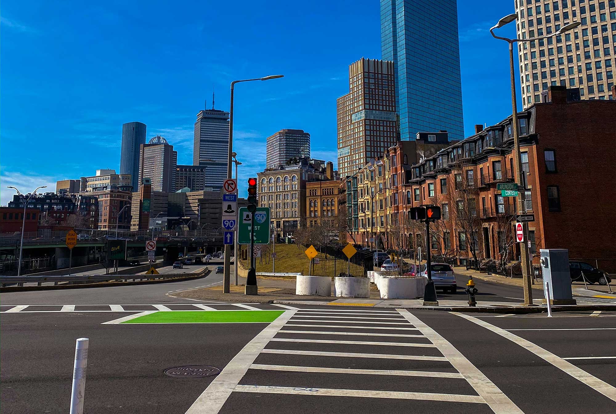 Crosswalk with city skyline in the background.