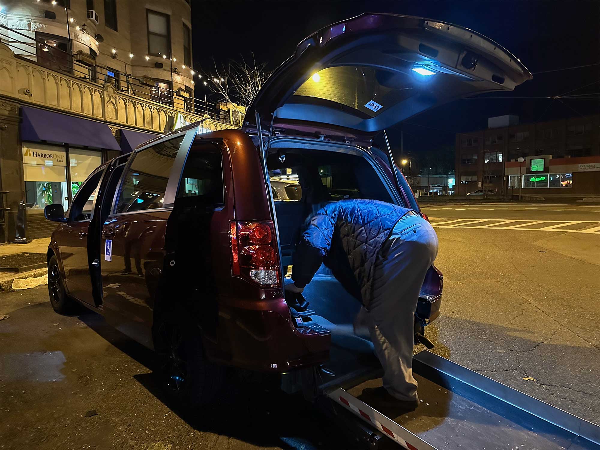 Van with rear ramp extended onto pavement.