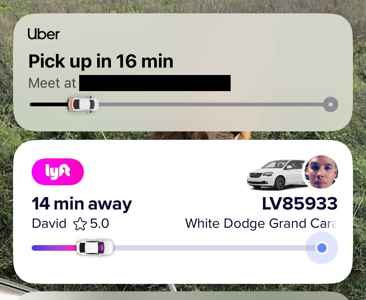 Two notifications on iPhone Home Screen showing Lyft and Uber vehicles en route to pick-up.