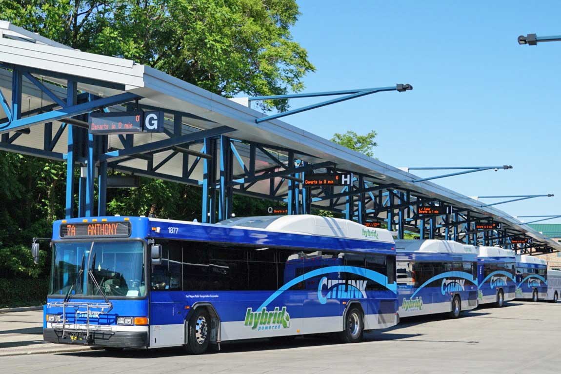 City buses parked at station.