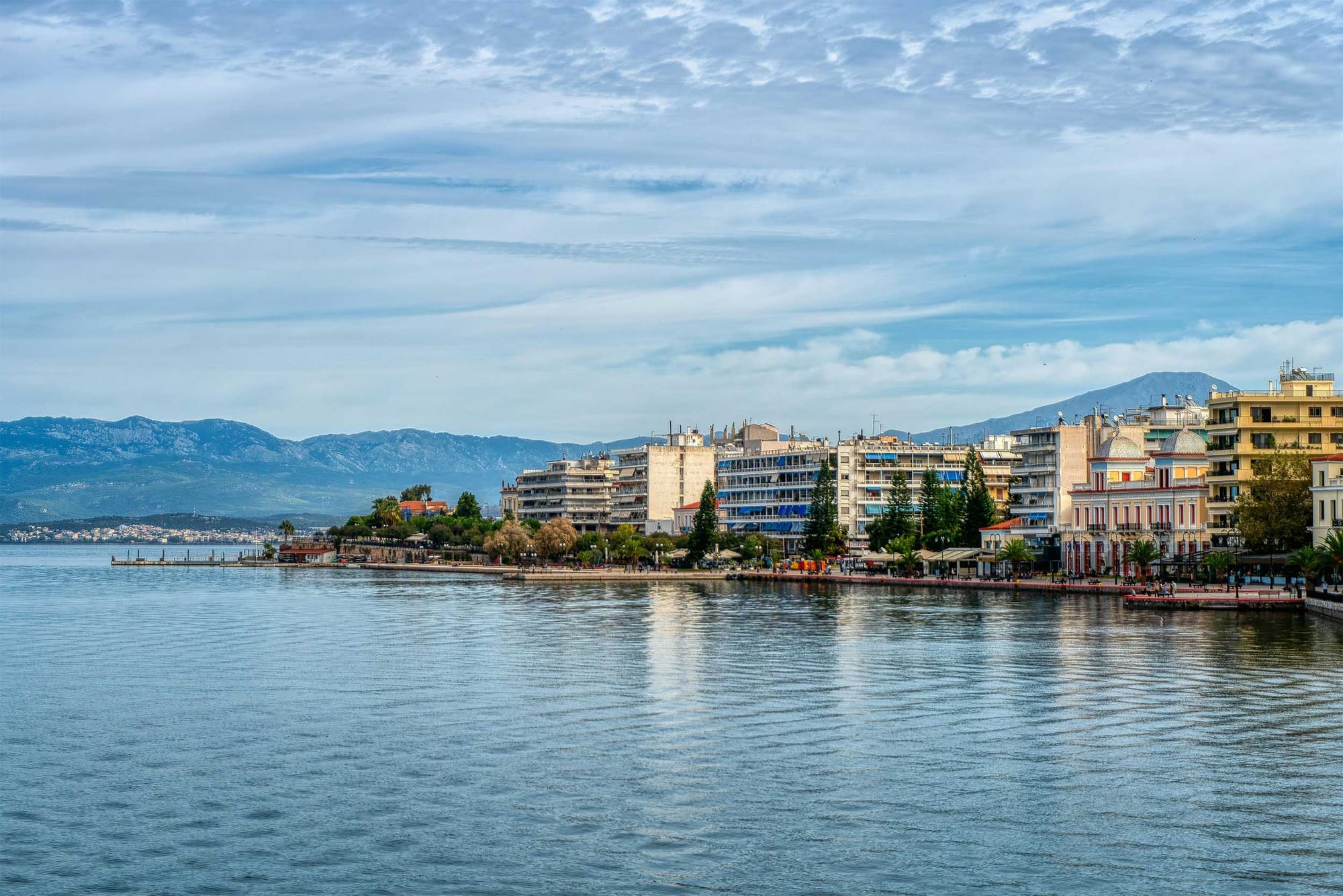 Coastal town with pedestrian walkway along water.